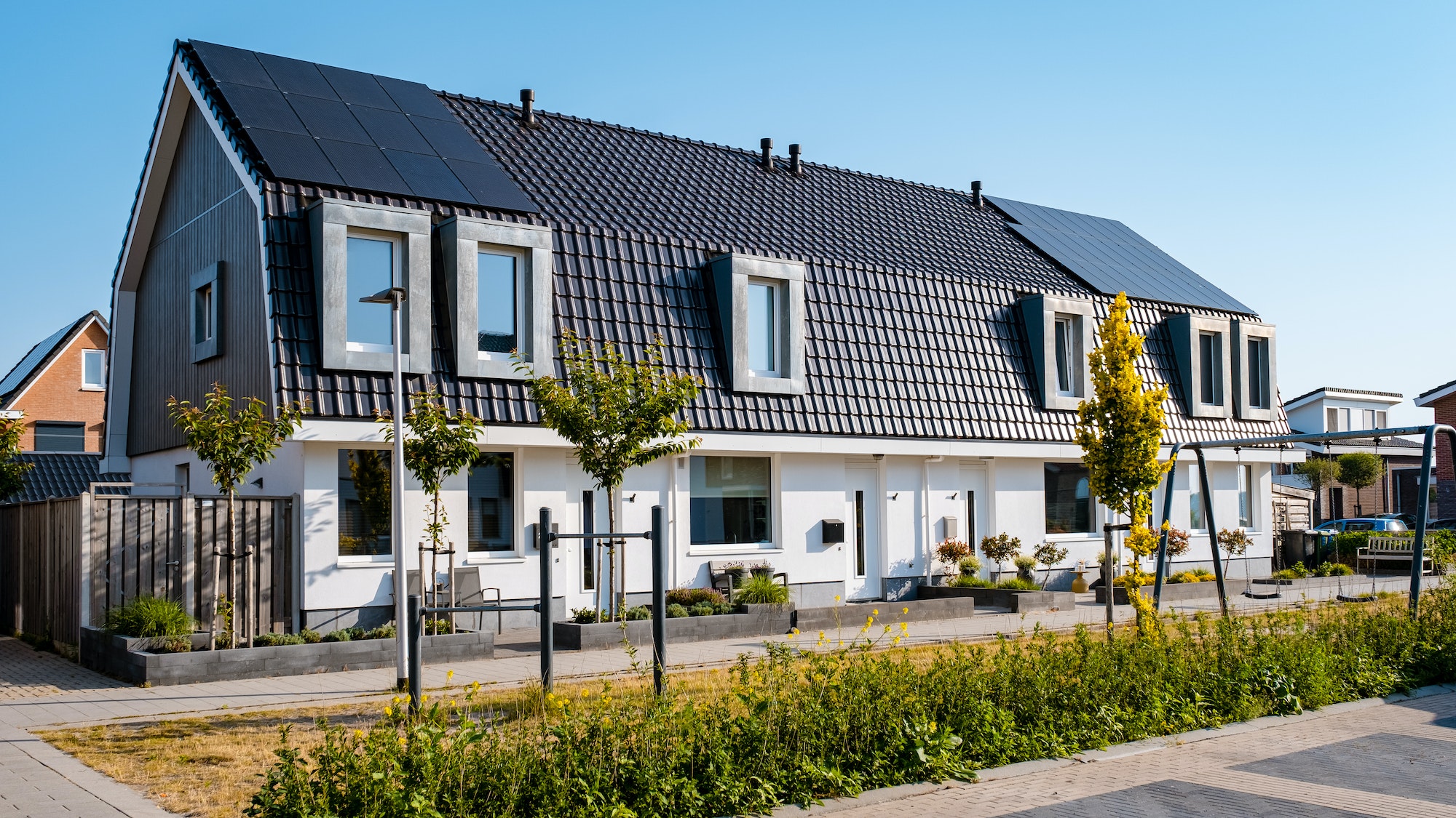 Newly build houses with solar panels attached on roof against a sunny sky Close up of solar pannel