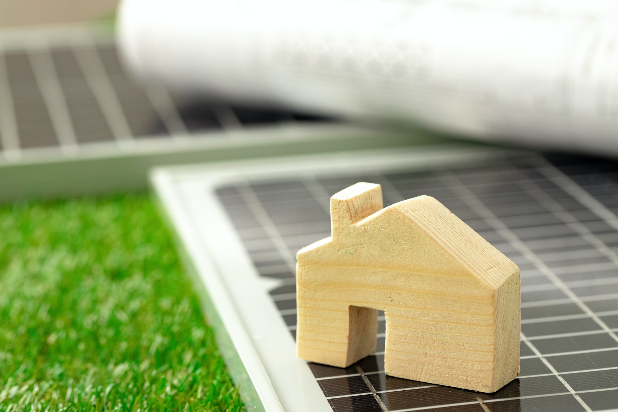 Wooden house miniature and solar panel close up